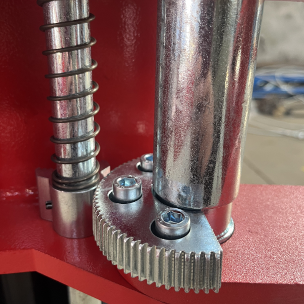 Close-up of a katool mechanical component with gears and springs on a red background